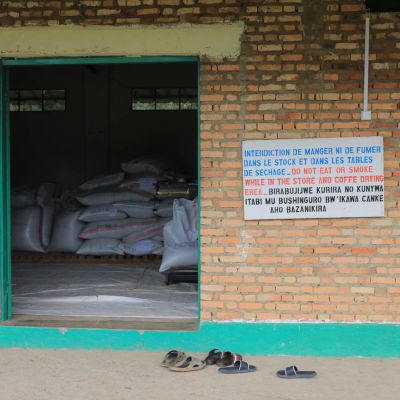 Looking through the door of a brick storage warehouse where the dried green coffee is kept in a cool environment before moving to the dry mill. Gahahe coffee mill, Kayanza, Burundi.