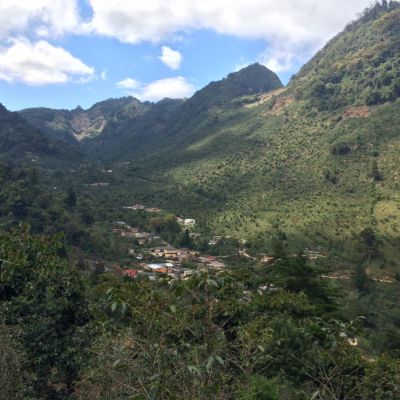 The green, lush mountain valley town of El Paraiso, sits beneath a patchwork of coffee farms on the surrounding mountain slopes. Huehuetenango, Guatemala.