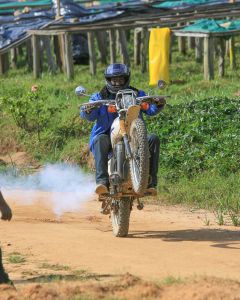 This coffee farmer shows off his wheelie skills on a dirt bike in front of the raised drying beds at the Mutovu coffee washing station in Nyamasheke, Rwanda.